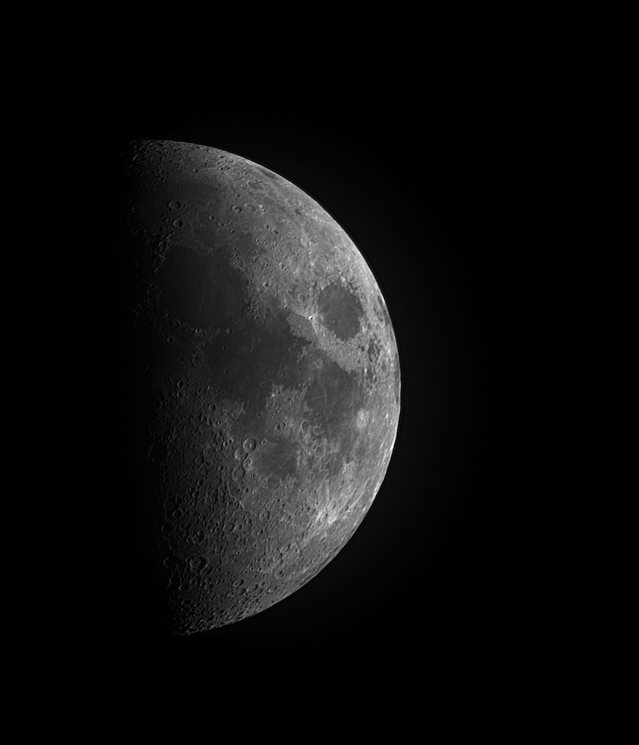 First-quarter Moon photographed through an amateur telescope: crater relief is deeply shadowed and three-dimensional along the terminator down the left, and fades to almost no shadow toward the sunlit limb on the right.